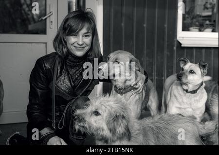 Cane in un rifugio. Un volontario rifugio per animali si prende cura dei cani. Un volontario si prende cura di un cane in un rifugio. Immagine in bianco e nero Foto Stock
