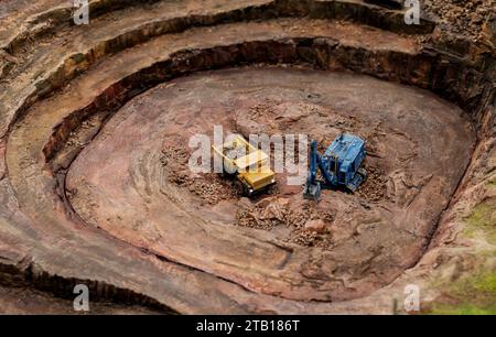 modello miniaturizzato di un dumper e di un escavatore in cava. industria edile e lavori su terreni Foto Stock