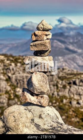 torre rocciosa composta da un mucchio di pietre zen, catena montuosa con sfondo nuvoloso Foto Stock