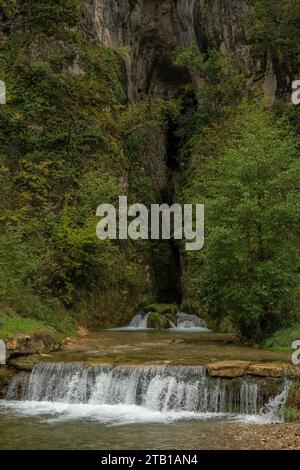 Fiume che emerge dalla grotta nel fiume Tarn nelle Gorges du Tarn, sotto l'altopiano del Causse Méjean a Lozère, in Francia. Foto Stock