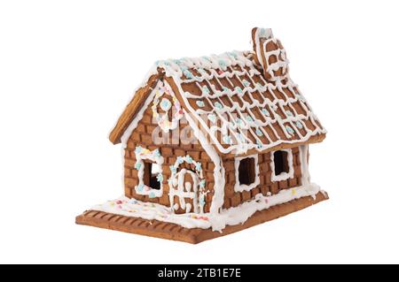 Casa di pan di zenzero di Natale in neve decorata con smalto, isolato su bianco Foto Stock