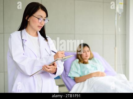 Ritratto di giovane medico donna con paziente sullo sfondo Foto Stock