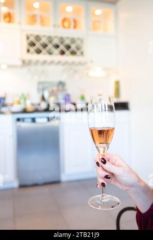 Mano di una donna che regge un bicchiere di champagne Foto Stock