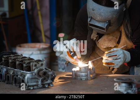 La saldatrice è la saldatura a gas inerte al tungsteno, la saldatura dell'alluminio con argon di alluminio, la torcia di saldatura TIG. Foto Stock