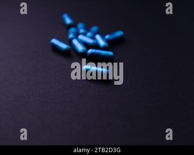 Capsule di aminoacidi su sfondo di carta scura. Messa a fuoco morbida. Primo piano. Copia spazio. Foto Stock
