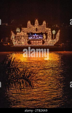 Il galleggiante illuminato proietta la sua riflessione sul fiume Tonle SAP durante il Festival dell'acqua cambogiano, Phnom Penh, Cambogia. © Kraig Lieb Foto Stock