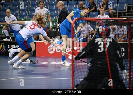 Singapore. 4 dicembre 2023. La svedese Ellen Rasmussen (R) tenta un colpo di rete durante la partita del gruppo B tra la Repubblica Ceca e la Svezia al Campionato mondiale di floorball femminile a Singapore il 4 dicembre 2023. Crediti: Poi Chih Wey/Xinhua/Alamy Live News Foto Stock