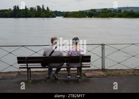 Una coppia in pensione siede su una panchina sulle rive del Reno. Foto Stock