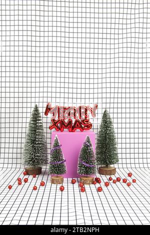 Un decoro natalizio di plastica rosso lucido con un testo che dice allegri natali con bauble di natale rosso e una scena forestale in miniatura composta da diversi elementi Foto Stock