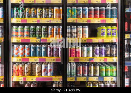 Una colorata e variegata collezione di birre artigianali britanniche e internazionali fredde in lattine in vendita in frigorifero al supermercato Morrisons, in Inghilterra Foto Stock