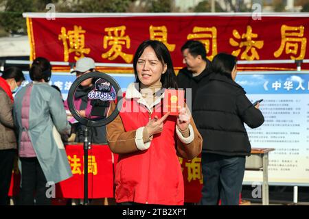 Pechino, provincia cinese di Henan. 4 dicembre 2023. Un membro dello staff dell'ufficio di giustizia locale pubblicizza la Costituzione attraverso il live streaming in un parco nella contea di Bo'ai di Jiaozuo, nella provincia di Henan della Cina centrale, 4 dicembre 2023. La Cina ha celebrato il suo decimo giorno della Costituzione nazionale lunedì. Crediti: Cheng Quan/Xinhua/Alamy Live News Foto Stock