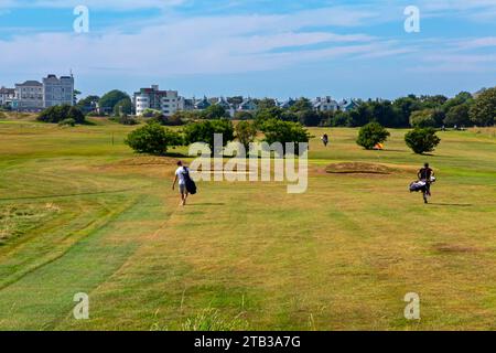 I golfisti che passeggiano nell'Hythe Golf Club vicino a Folkestone nel Kent Inghilterra Regno Unito in estate con cielo blu sopra. Foto Stock