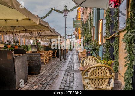 Passeggia tra i ristoranti colorati sul molo del canale di Nyhavn a Copenaghen, 25 novembre 2023 Foto Stock