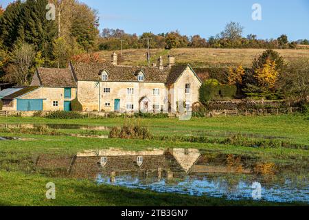 Stowel Mill (o Yanworth Mill) riflesso nell'acqua alluvionale del fiume Coln vicino al villaggio Cotswold di Yanworth, Gloucestershire, Inghilterra Regno Unito Foto Stock