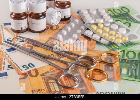 Strumenti medici e medicinali su una tabella coperti da un’ampia quantità di banconote in euro su sfondo chiaro primo piano Foto Stock