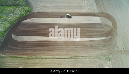 Campo di aratura del trattore. Agricoltore che lavora su campi di grano. Foto Stock