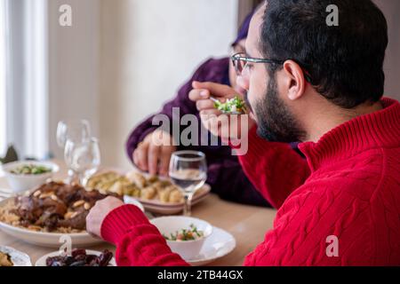 un giovane uomo barbuto che parla con sua madre durante il pranzo Foto Stock