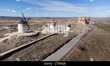 Vecchi mulini a vento in linea con il Castillo de la Muela sullo sfondo, nella città di Consuegra situata nella provincia di Toledo, in Spagna. Tipico Span Foto Stock