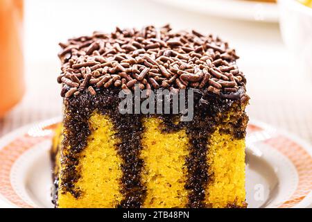 torta di carote con spolverini di cioccolato, glassa cremosa che gocciola la torta, servita con latte Foto Stock