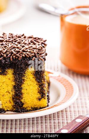 torta di carote con spolverini di cioccolato, glassa cremosa che gocciola la torta, servita con latte Foto Stock