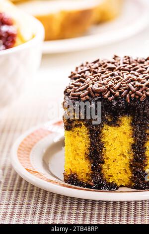 torta di carote con spolverini di cioccolato, glassa cremosa che gocciola la torta, servita con latte Foto Stock