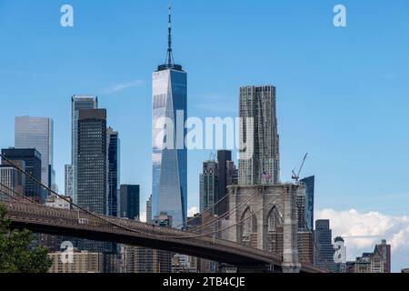 Vista dall'angolo basso dal Brooklyn Bridge Park sul lungomare al Ponte di Brooklyn a Lower Manhattan, New York, USA con i grattacieli di Lower Manhattan, Foto Stock