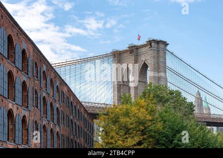 Vista dall'angolo basso del Ponte di Brooklyn con Lower Manhattan, New York City sullo sfondo e l'ex complesso di magazzini merci (chicchi di caffè, zucchero) Empire Store Foto Stock