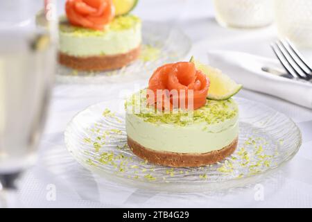 Antipasto timbale a base di avocado, montato con crema di formaggio soffice e lime su crosta corta con salmone. Un'ottima opzione per un menu delle vacanze. Foto Stock