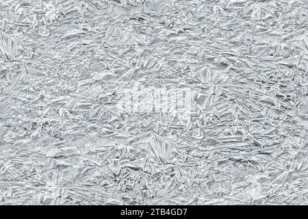 Ghiaccio su un fiume ghiacciato che forma strutture simili a cristalli, primo piano dettagli macro dall'alto - sfondo invernale astratto trasformato in una texture tagliabile senza cuciture Foto Stock