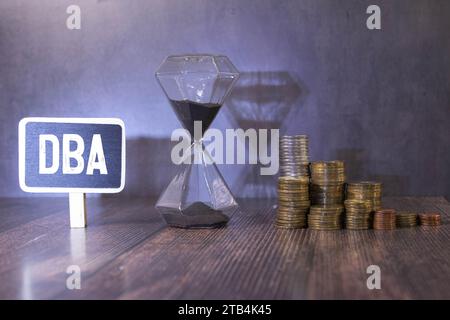 DBA - acronimo da blocchi di legno con lettere, amministratore di database o fare affari come abbreviazione DBA concetto, lettere casuali intorno, grigio backg Foto Stock