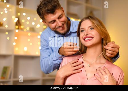 Uomo amorevole che regala collana a una donna felice Foto Stock