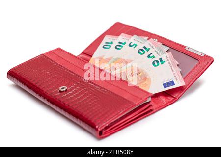 Aperto Red Women Purse con banconote da 10 euro all'interno - isolato su sfondo bianco. Un portafoglio pieno di soldi che simboleggia ricchezza, successo, shopping e status sociale - isolamento Foto Stock