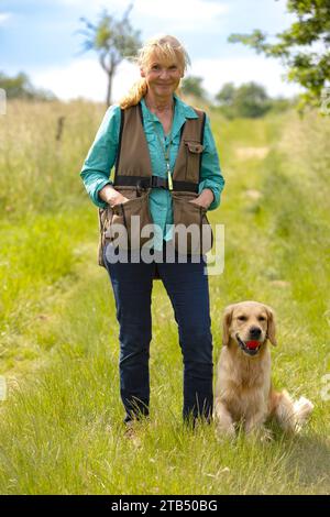 Donna che indossa un manichino e il suo obbediente Golden retriever Foto Stock