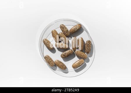 Multivitamine in una capsula da laboratorio su sfondo bianco. Pillole, integratori alimentari e vitamine. Foto Stock