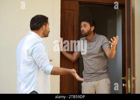 Vicini emotivi che discutono vicino alla casa all'aperto Foto Stock