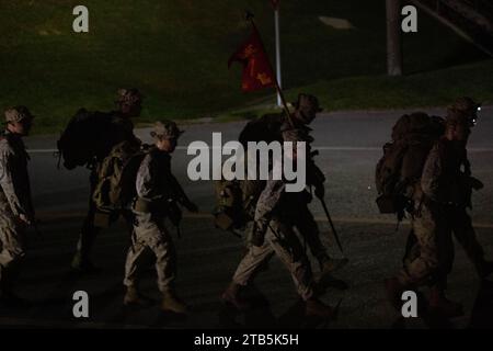 U.S. Marines with 5th Air Naval Gunfire Liaison Company, III Marine Expeditionary Force Information Group, conducono un'escursione di sei miglia sotto carico a Camp Hansen, Okinawa, Giappone, 1 dicembre 2023. Il 1st Brigade Platoon ha effettuato un'escursione di condizionamento per preparare i Marines per i movimenti a lunga distanza sotto carico, mantenere la forma fisica e costruire espirit de Corps. (Foto del corpo dei Marines degli Stati Uniti del cpl. Angel Diaz Montes De Oca) Foto Stock