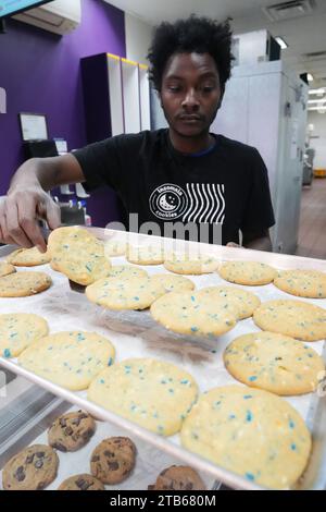 University City, Stati Uniti. 8 dicembre 2023. Il manager Trevion Henderson sposta i biscotti freschi alla vetrina dell'Insomnia Cookies in occasione del National Cookie Day a University City, Missouri, lunedì 4 dicembre 2023. Foto di Bill Greenblatt/UPI credito: UPI/Alamy Live News Foto Stock