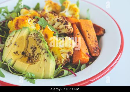Insalata invernale calda con cavolfiore arrosto, patate dolci e avocado, primo piano. Foto Stock