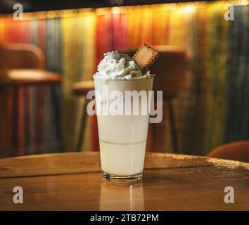 Bicchiere di cioccolata calda bianca con panna montata decorata con biscotti Foto Stock