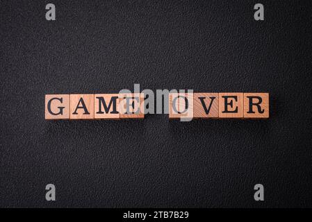 Il gioco delle iscrizioni su cubi di legno su uno sfondo di cemento scuro. Può essere utilizzato come parte della composizione Foto Stock