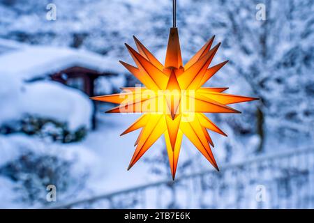 Weihnachtsstern hängt im Fenster, Blick auf den verschneiten Garten, München, Dezember 2023 Deutschland, München, Dezember 2023, Weihnachtsstern hängt im Fenster, Blick auf den tief verschneiten Garten, Herrnhuter Stern, Weihnachtsdeko, Weihnachtszeit, 2023, Bayern, *** la stella del Natale è appesa alla finestra, vista sul giardino innevato, Monaco, dicembre 2023 Germania, Monaco, dicembre 2023, stella di Natale appesa alla finestra, vista sul giardino innevato, stella Herrnhut, decorazione natalizia, periodo natalizio, 2023, Bavaria, Credit: Imago/Alamy Live News Foto Stock