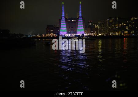 Londra, Regno Unito. 4 dicembre 2023. Utilizzando un ipad, David Hockney ha creato due grandi alberi di Natale a righe verdi e viola, ciascuno con una stella d'oro in cima, esposti sulle centrali elettriche due camini alti 100 metri che si affacciano sul Tamigi. L’opera d’arte natalizia è quella di portare “gioia e speranza” alle persone di Londra, Regno Unito. Crediti: Mary-Lu Bakker/Alamy Live News Credit: Mary-Lu Bakker/Alamy Live News Foto Stock