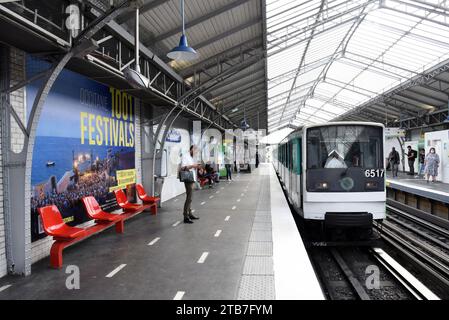 Parigi, 2022/06/23 (Francia): Passeggeri sui marciapiedi e treno che arrivano alla stazione di volo 'Chevaleret' (linea 6) in Boulevard Vincent-Auriol, in t Foto Stock