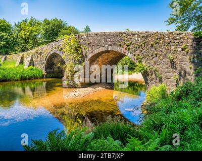 Il vecchio ponte sul fiume West Dart a Two Bridges su Dartmoor, Devon. Foto Stock