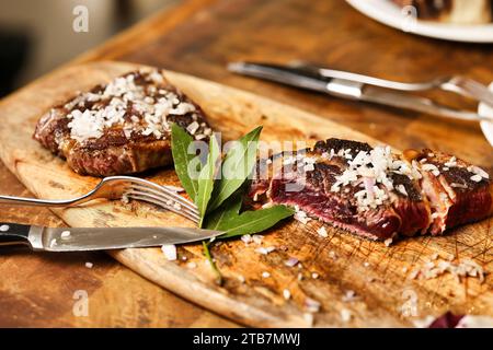 Preparazione di una bistecca di costolette “entrecote Bordelaise” (bistecca alla Bordeaux), Bazas beef. Carne presentata su una tavola, carne rara Foto Stock