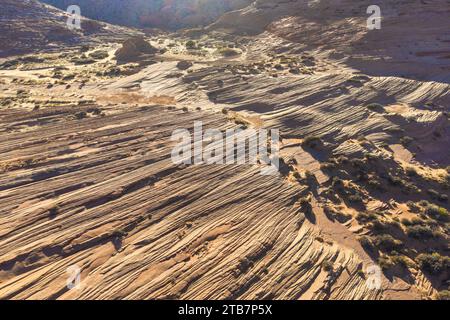 Ripresa aerea che cattura gli intricati schemi delle formazioni rocciose del deserto con varie sfumature di marrone e arancione. Foto Stock