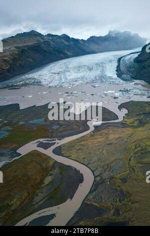 Un colpo aereo cattura l'enorme bellezza di un ghiacciaio che scorre in un fiume intrecciato nel Parco Nazionale Vatnajokull in Islanda. Foto Stock