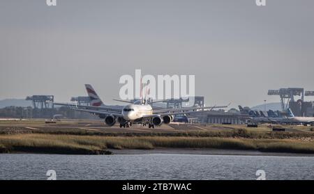 Una fila di aerei commerciali si sono allineati come taxi prima di decollare in un aeroporto di Boston Foto Stock
