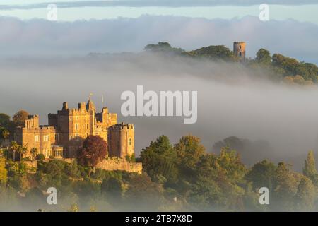 Dunster Castle e Conygar Tower che emergono dalla Morning Mist, Dunster, Exmoor National Park, Somerset, Inghilterra. Autunno (ottobre) 2022. Foto Stock