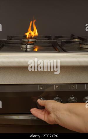 la mano della donna che accende il gas sul concetto di costo energetico della stufa da cucina Foto Stock